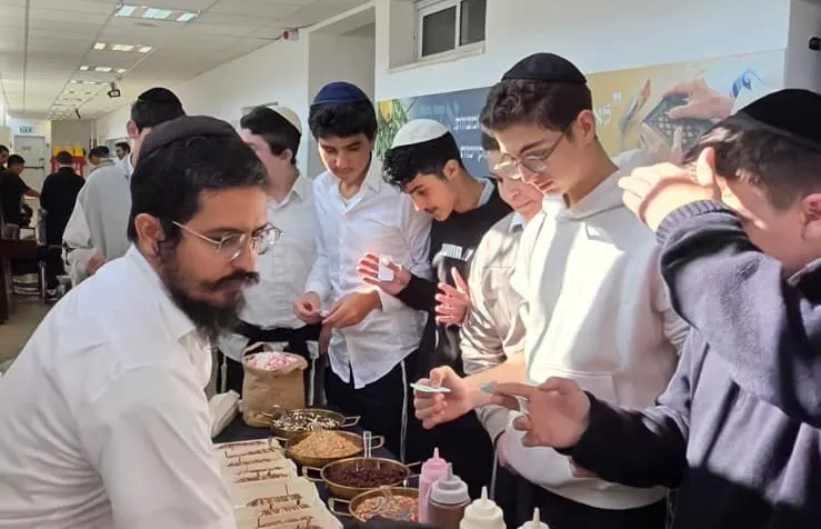 איש צוות מחלק מנות מתוקות לתלמידים בדוכן - מבחן של חורף