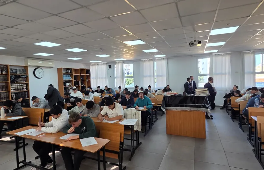 תלמידים כותבים מבחן באולם הלימוד מול ספריות - מבחן של חורף