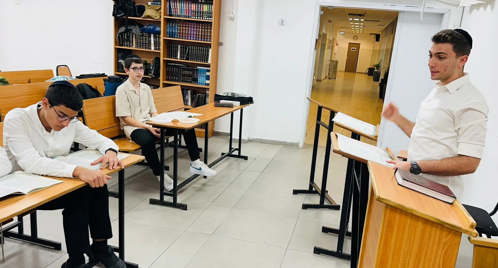 תלמיד מדבר ליד בימת בית המדרש - בזוגות מול הספר