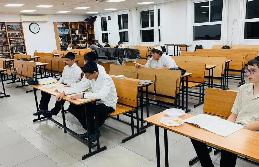 תלמידים לומדים סביב שולחנות בית המדרש - בזוגות מול הספר