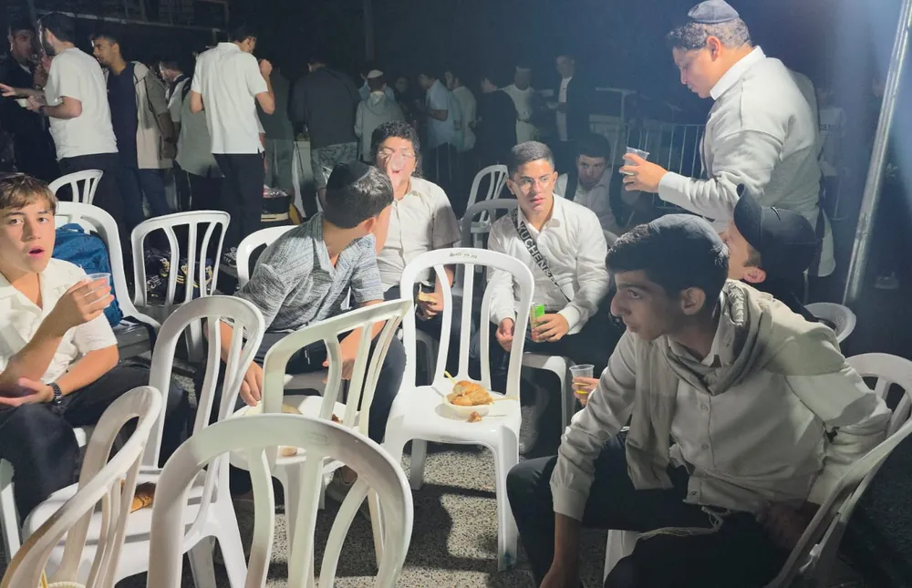 תלמידים משוחחים סביב כיסאות - ליל סליחות במירון