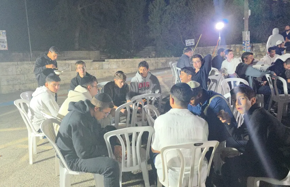 תלמידים סביב כיסאות בארוחה - ליל סליחות במירון