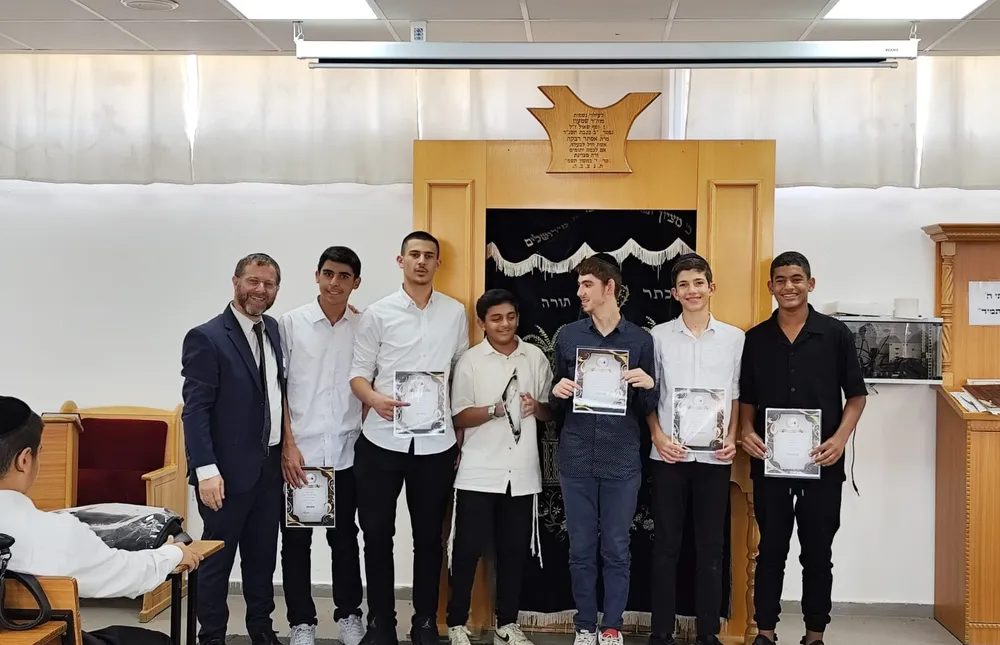 מצטיינים עומדים עם איש צוות ותעודות ליד ארון הקודש - כל שבוע, מישהו אחר