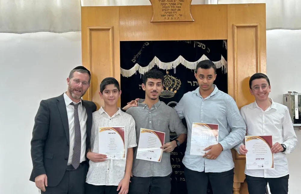 ארבעה מצטיינים עם תעודות ואיש צוות בפתח ארון הקודש - כל שבוע, מישהו אחר