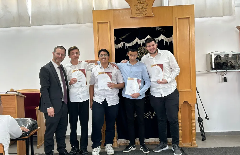 מצטייני השבוע פרשת לך לך - ארבעה תלמידים עם תעודות ליד ארון הקודש - כל שבוע, מישהו אחר