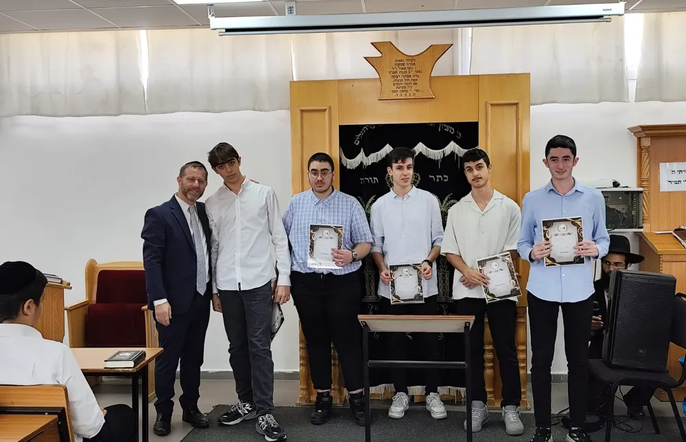 חמישה מצטיינים ואיש צוות עומדים לצילום מול ארון הקודש - כל שבוע, מישהו אחר