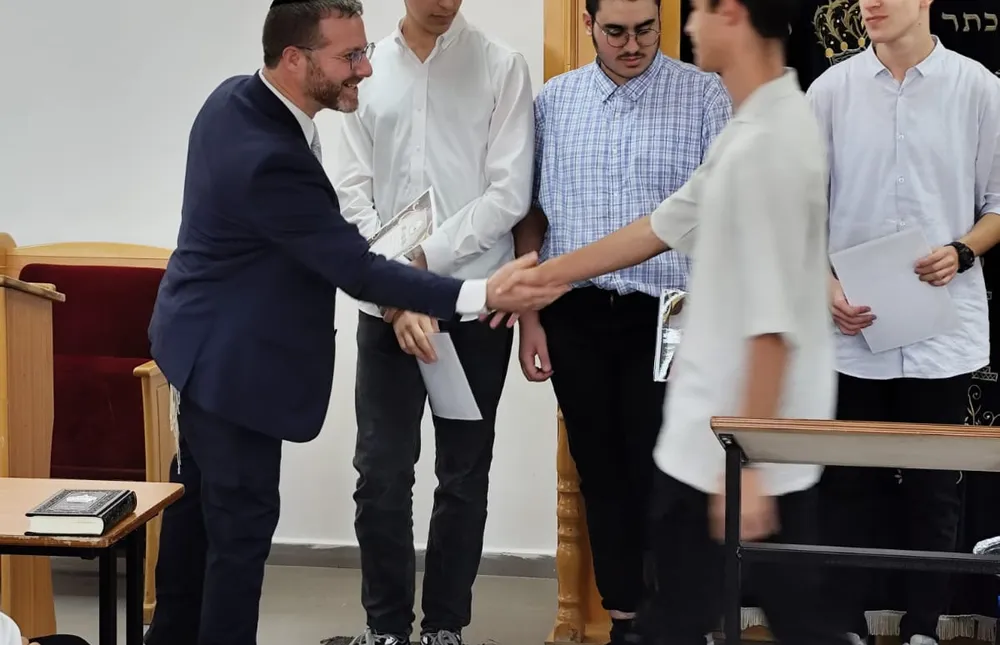 תלמיד לוחץ יד למעניק תעודה לצד שלושה מצטיינים - כל שבוע, מישהו אחר