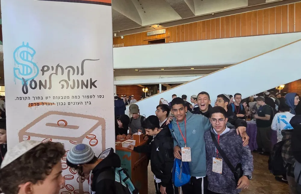 שני תלמידים עם תגי משתתף מצטלמים בלובי - אותיות של ביטחון
