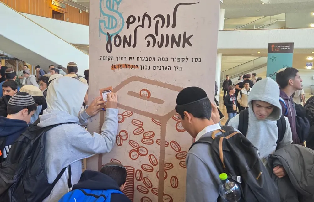 תלמידים פותרים חידה על עמוד פעילות באולם - אותיות של ביטחון