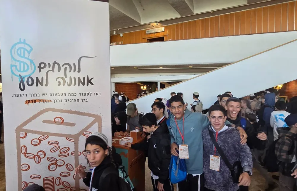 תלמידים עם תגי כניסה ליד עמדת משחק בלובי - אותיות של ביטחון