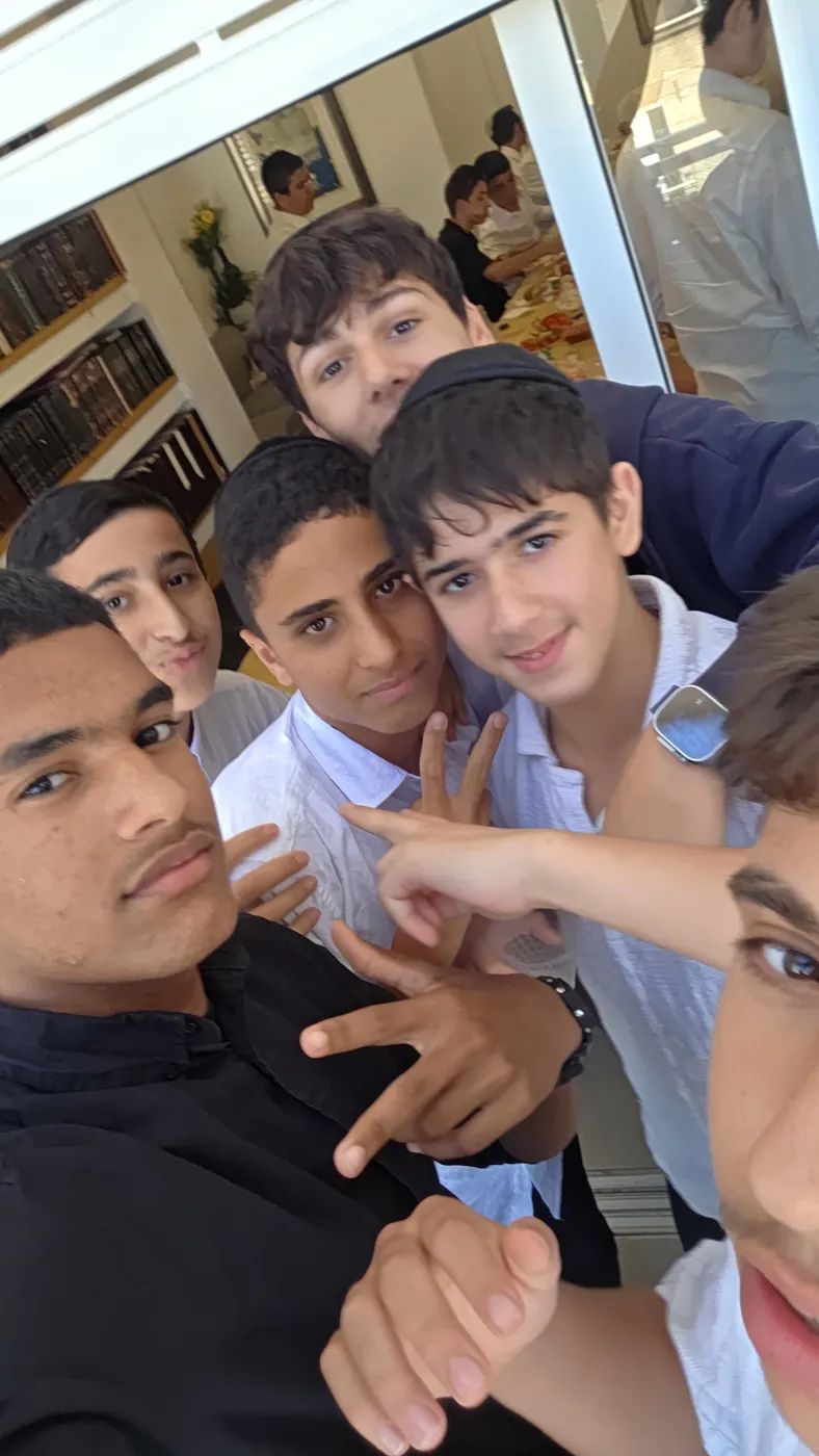 סלפי תלמידים מחייכים ליד שולחן הארוחה - בוקר ערכי לשיעור א׳ בראש חודש תמוז