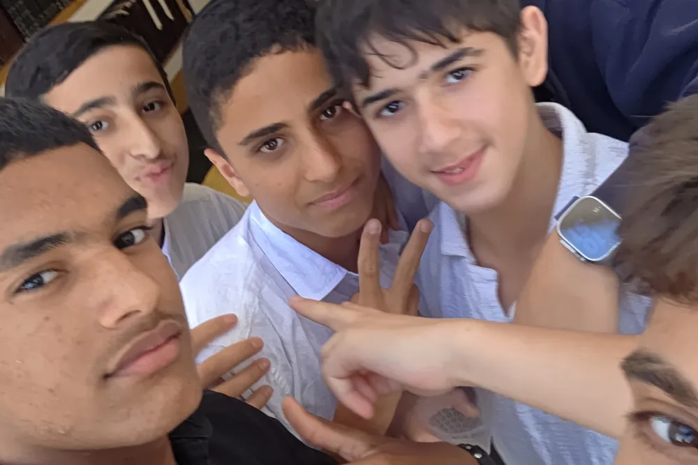 סלפי תלמידים מחייכים ליד שולחן הארוחה - בוקר ערכי לשיעור א׳ בראש חודש תמוז